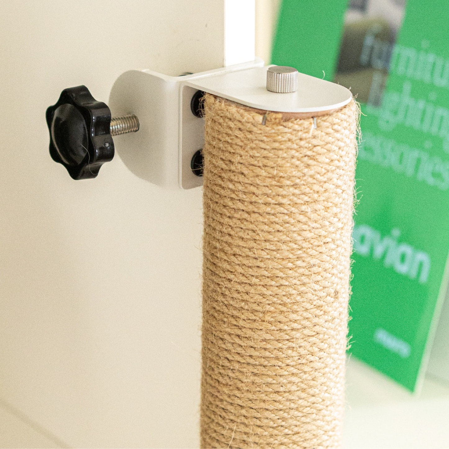 Close-up of a natural jute scratching post secured with a white clamp